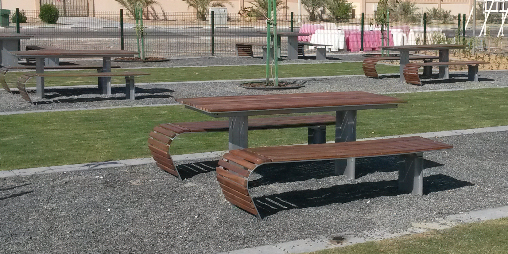 Picknickset Contour. Afgebeeld met een fraaie kersen-afwerking en de ijzerdelen gepoedercoat in een grijze ral kleur. Straatmeubliair op zijn mooist.