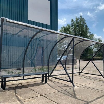 Hier uitgevoerd als fietsoverkapping - rookoverkapping combinatie. 3 meter fietsparkeren rechts en links voor de rokers. Totale lengte 6 meter.